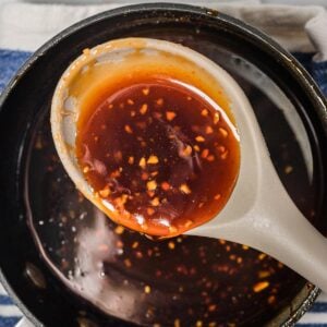Honey sriracha sauce in a spoon over a skillet