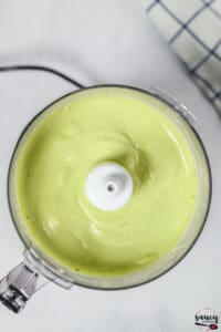 Blended smooth avocado crema in a food processor