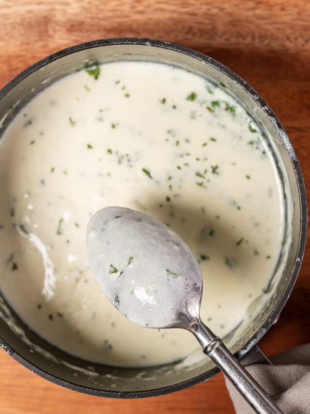 white garlic sauce with a spoon in a bowl