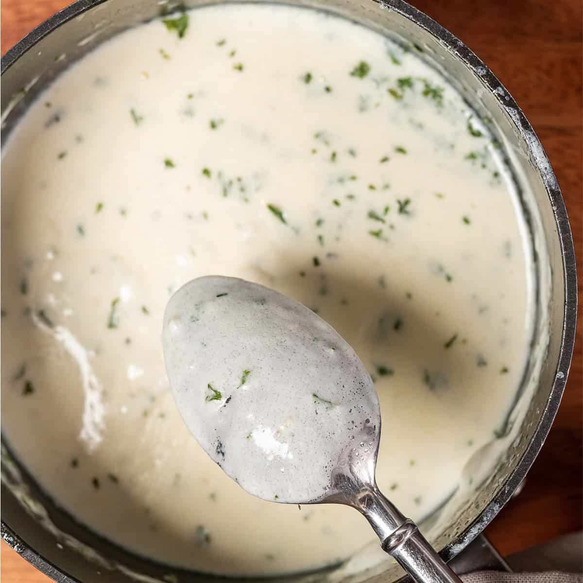 Garlic cream sauce in a bowl with a spoon