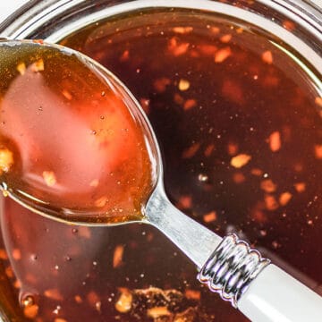 honey sriracha sauce on a spoon over a jar