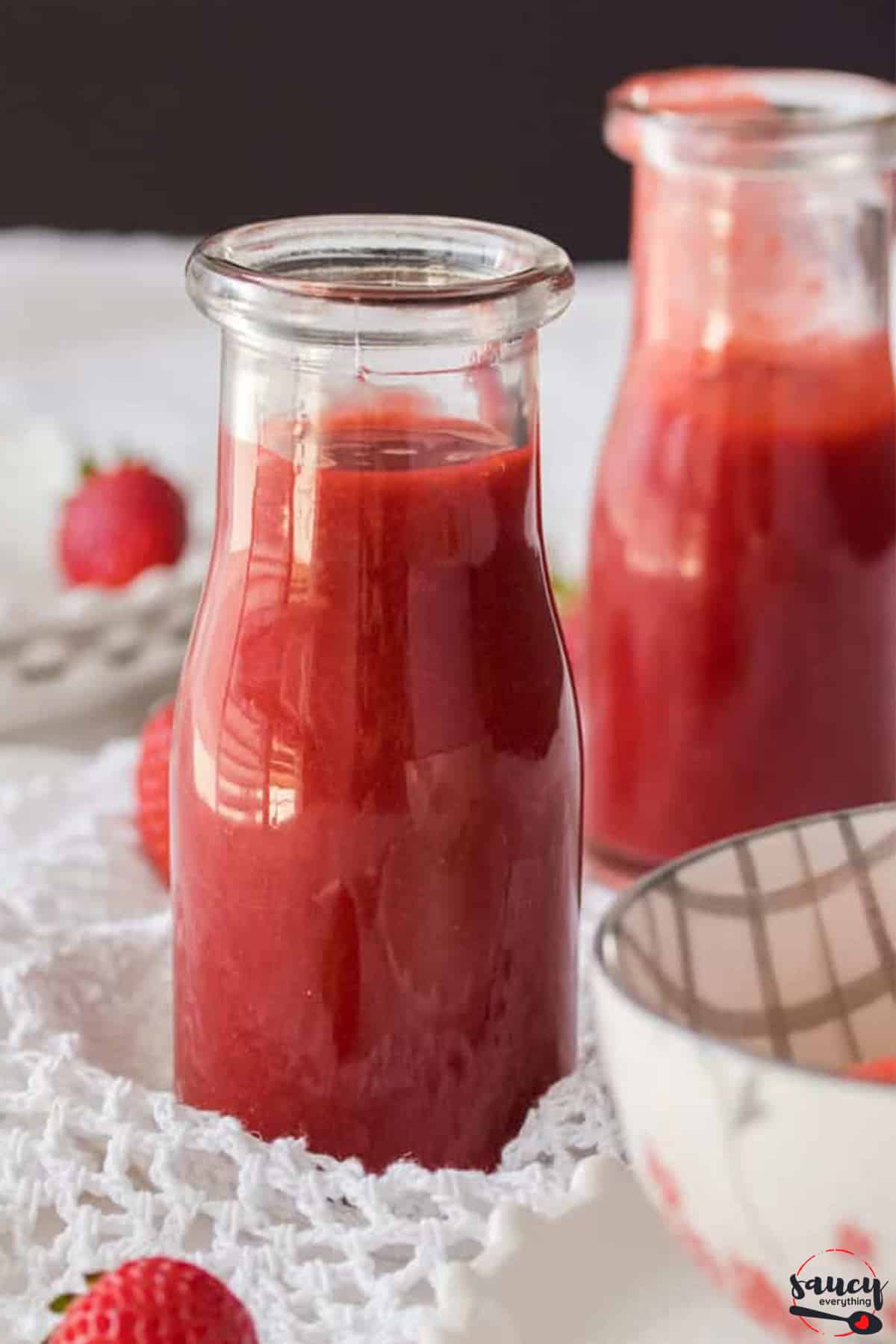Strawberry sauce in two containers up close
