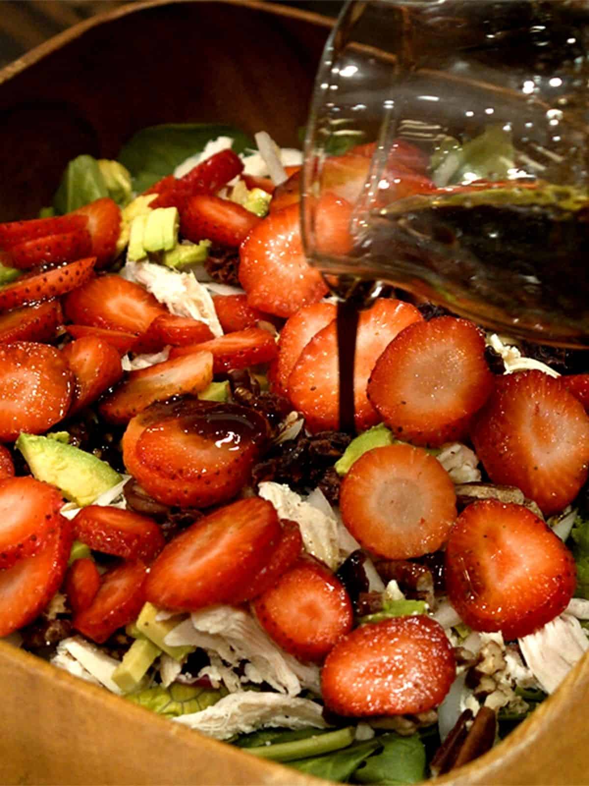 honey balsamic dressing being poured onto salad