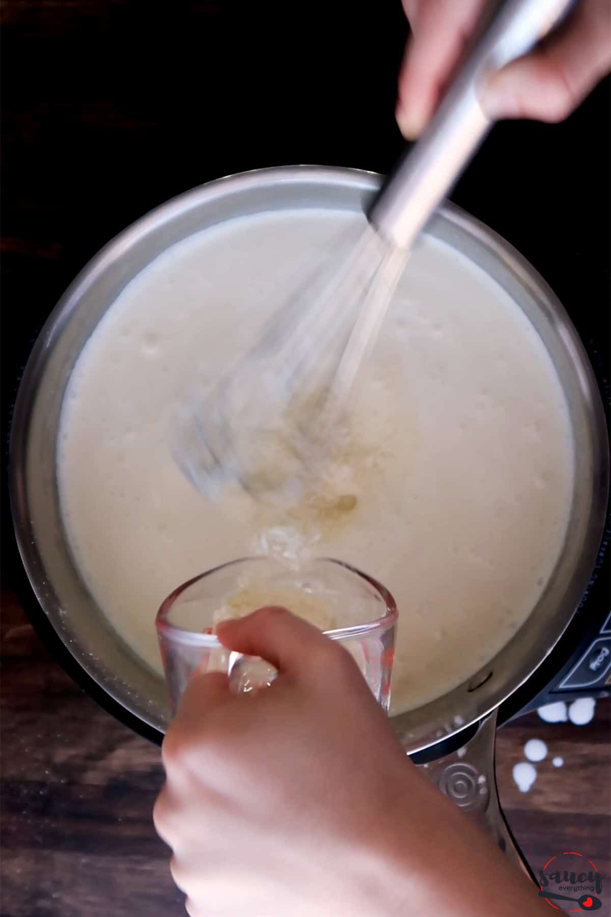 whisking parmesan into heavy cream in a skillet