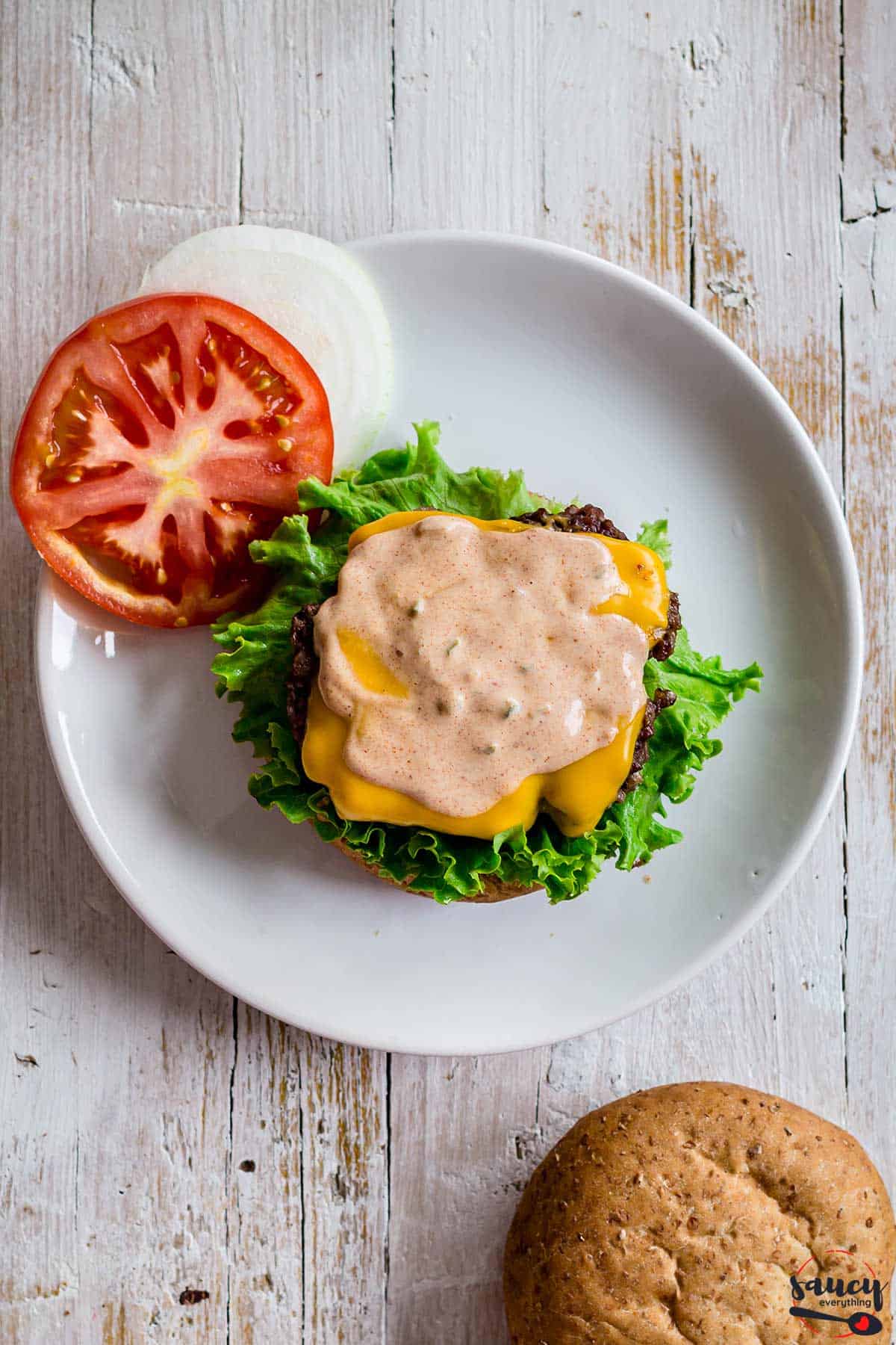 open face burger topped with burger sauce on a plate