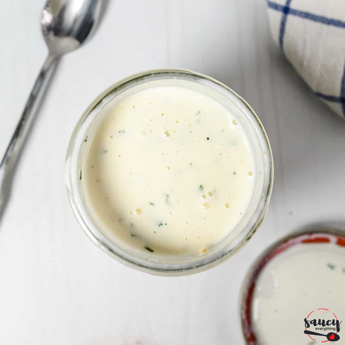 Buttermilk ranch dressing in a glass jar with a spoon