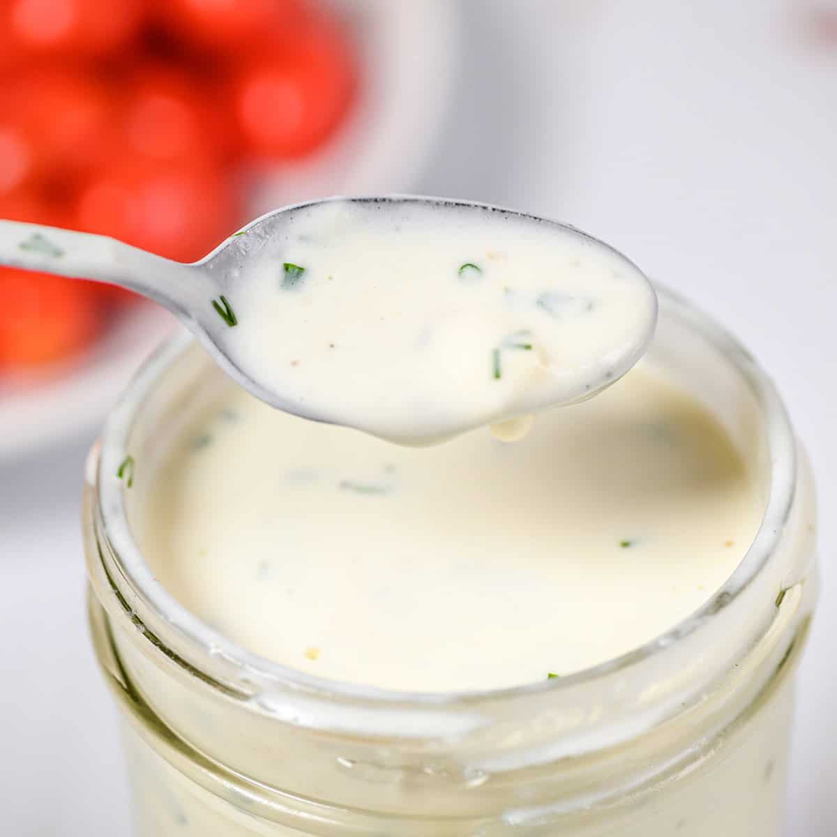 A spoonful of buttermilk ranch dressing over a jar