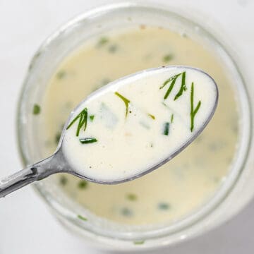 A spoonful of homemade ranch dressing over a jar of dressing