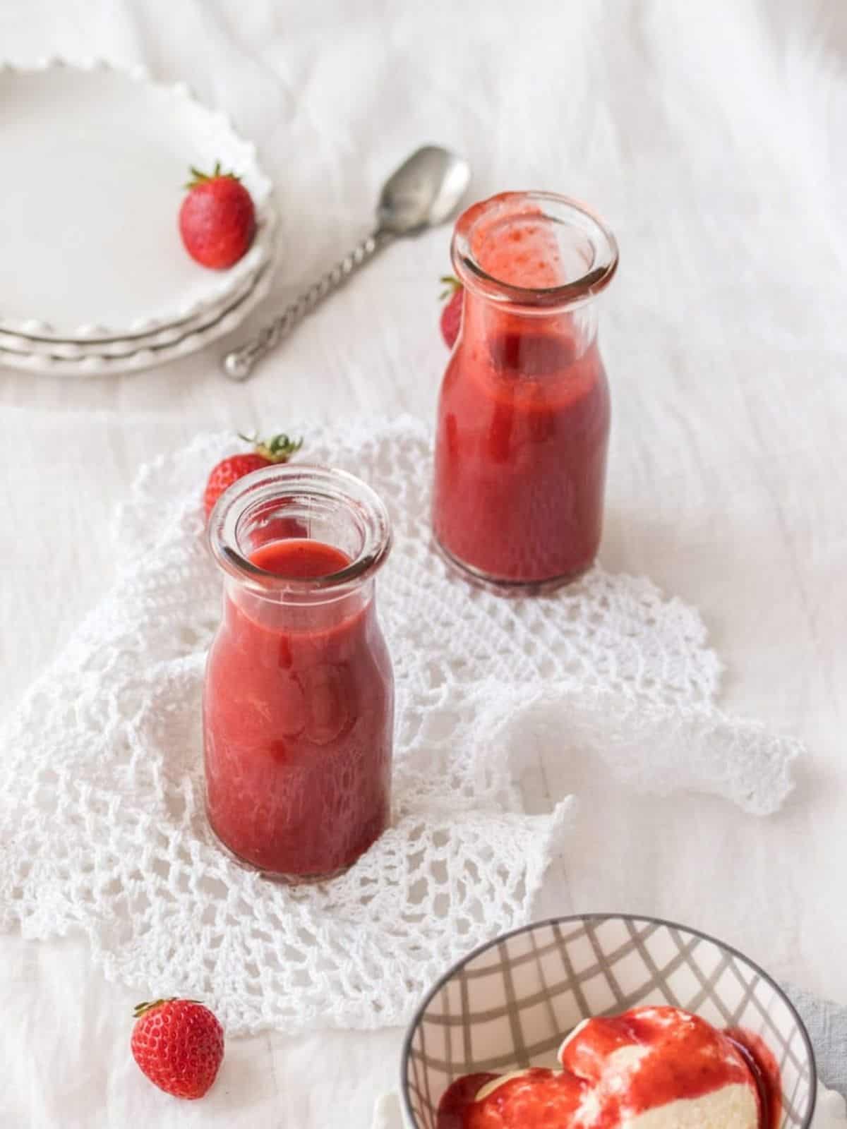 Strawberry sauce in two glass jars.