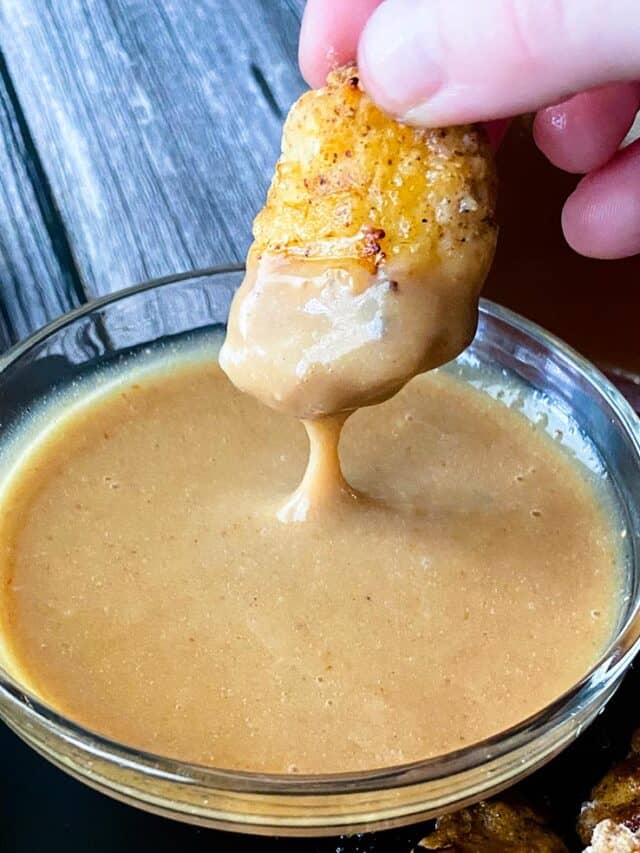 Chicken nugget being dipped into Chick-fil-A sauce.