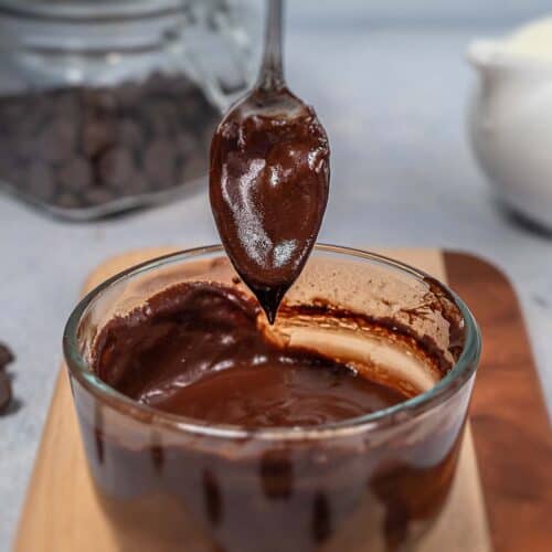 Drizzling chocolate sauce with a spoon into a bowl