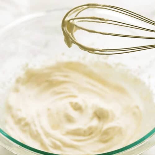 Whipped cream in a bowl with a whisk