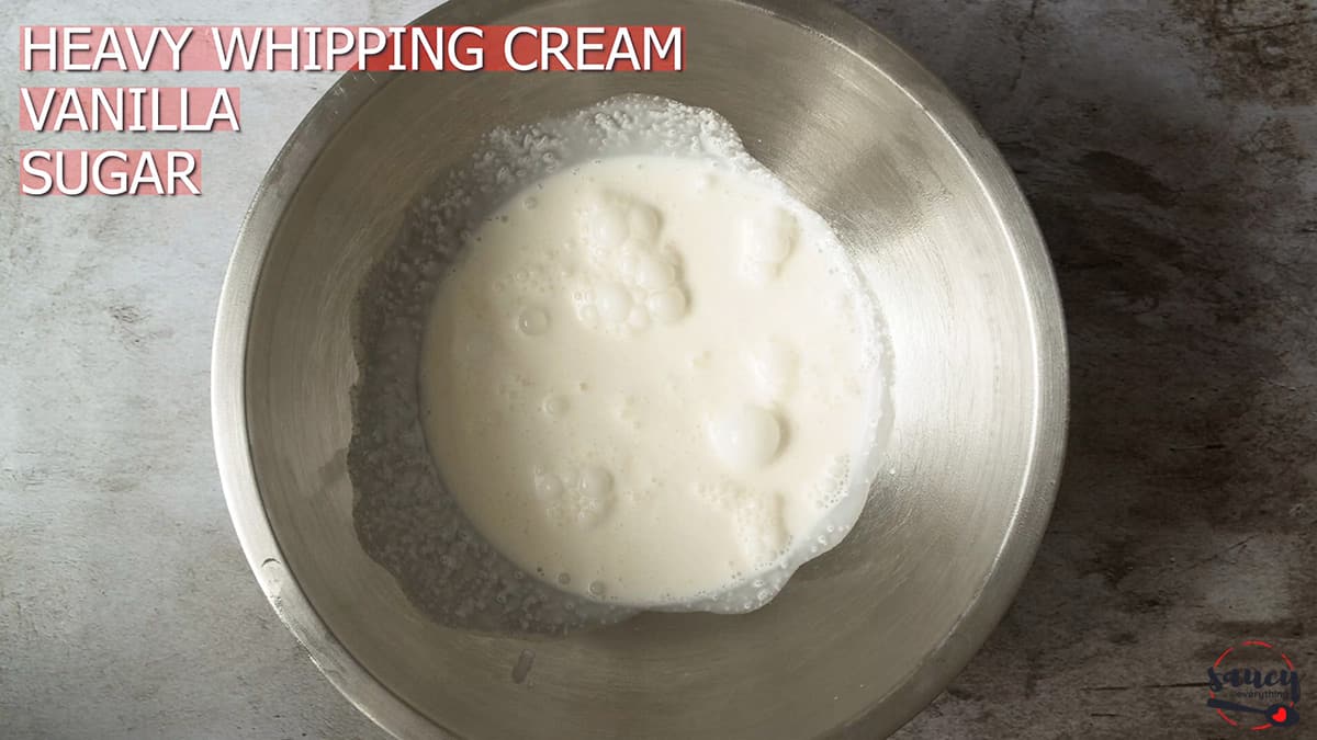 Ingredients for whipped cream in metal mixer bowl