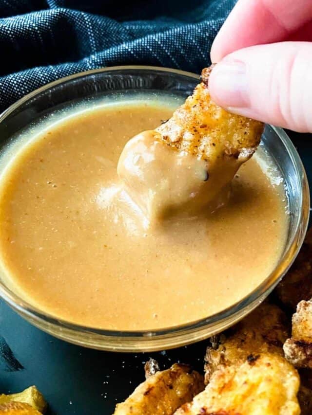 Chick-fil-A nugget being dipped in Chick-fil-A sauce.