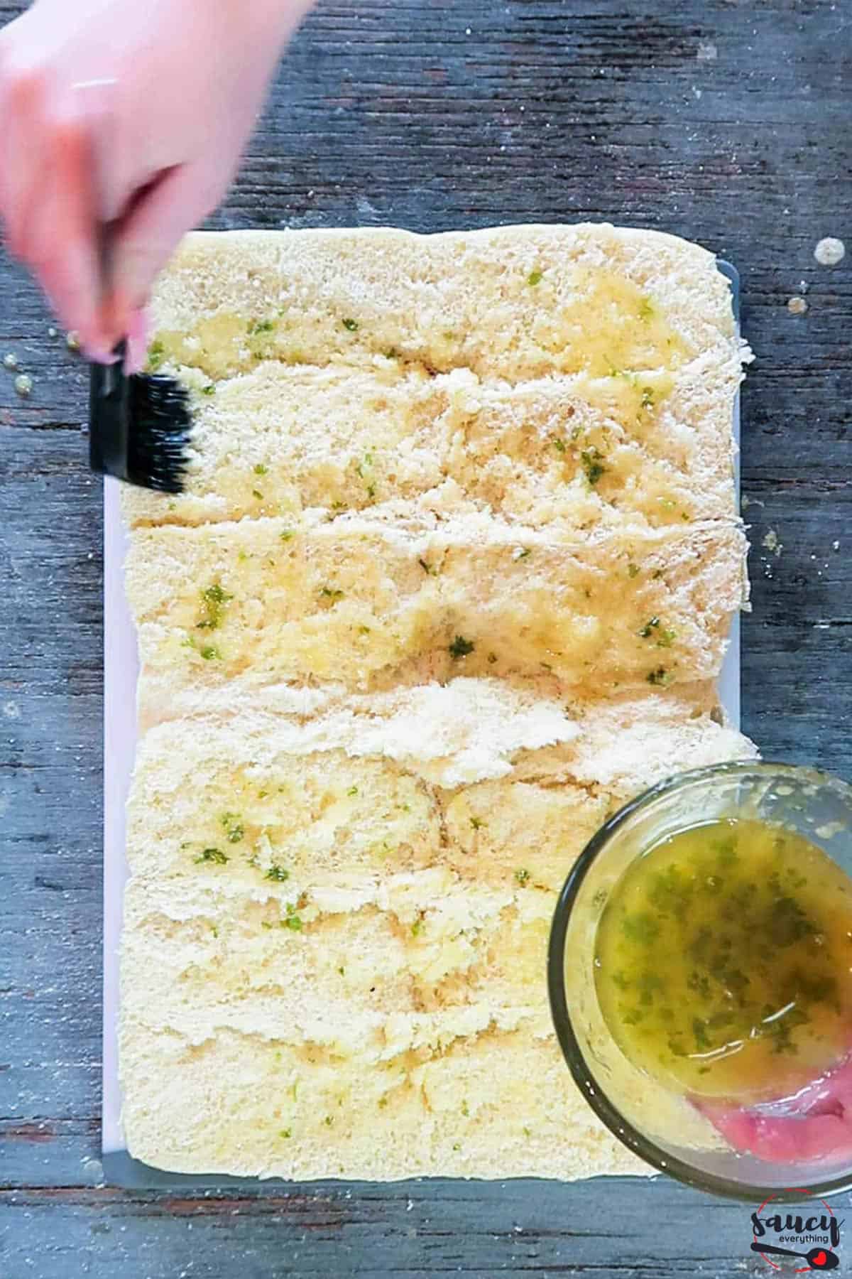 spreading garlic butter on bread