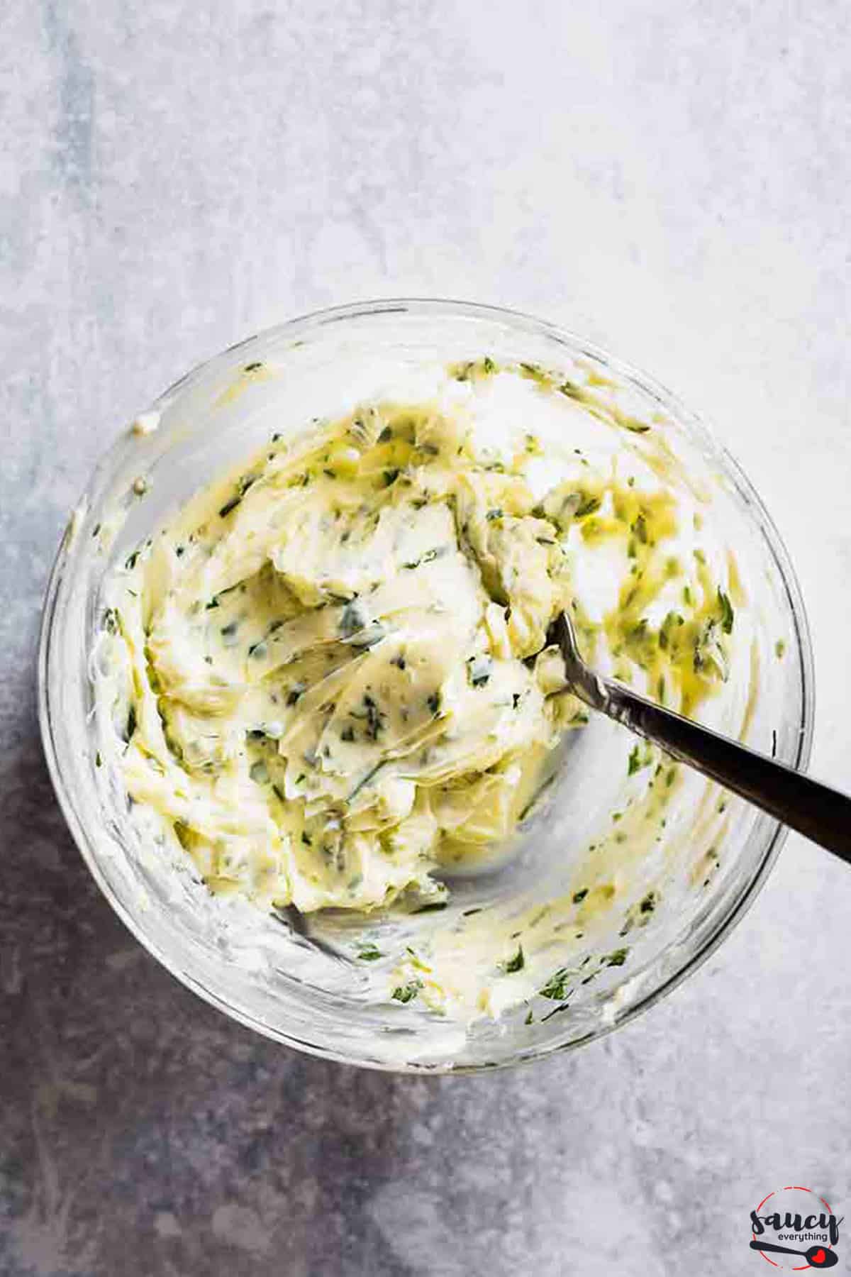 garlic butter in a glass bowl with a spoon