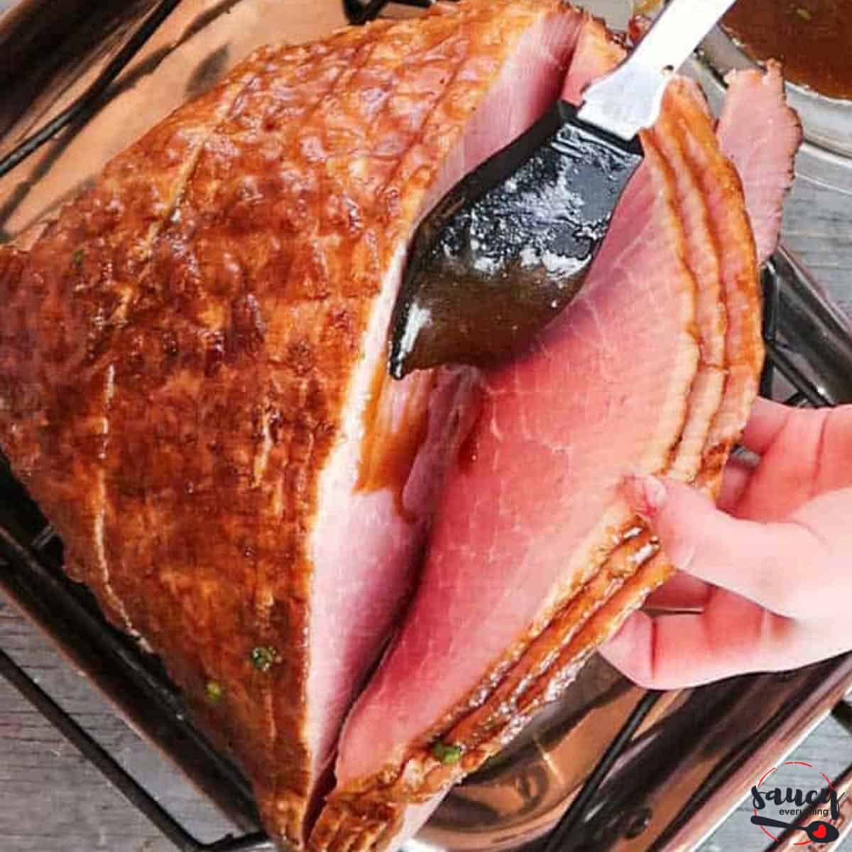Spreading glaze between each slice of ham