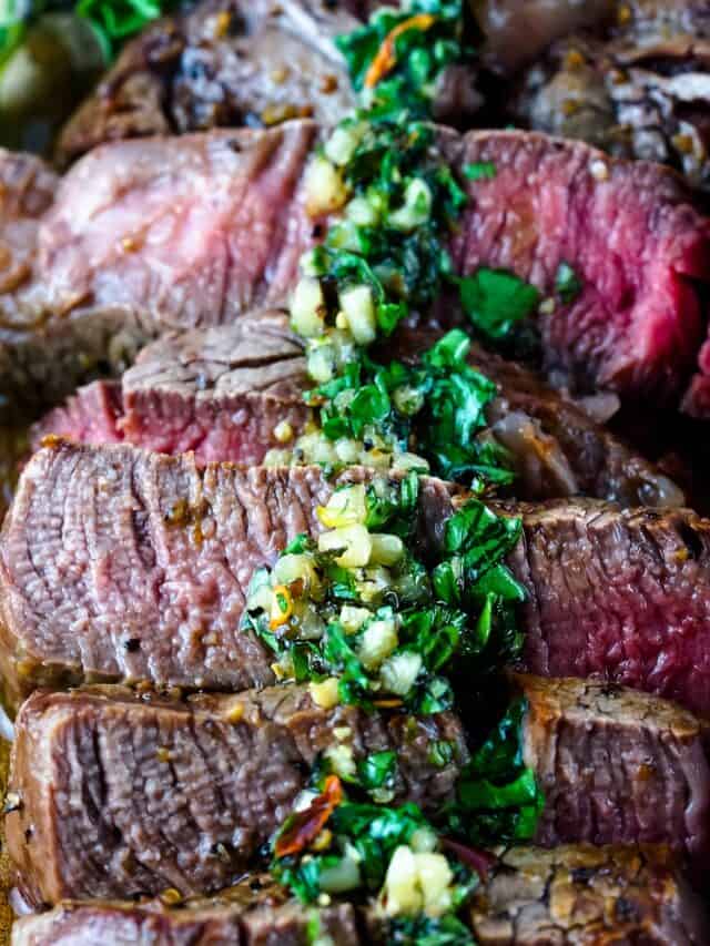 Chimichurri sauce being spooned over steak