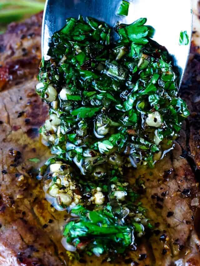 Chimichurri sauce being spooned over steak