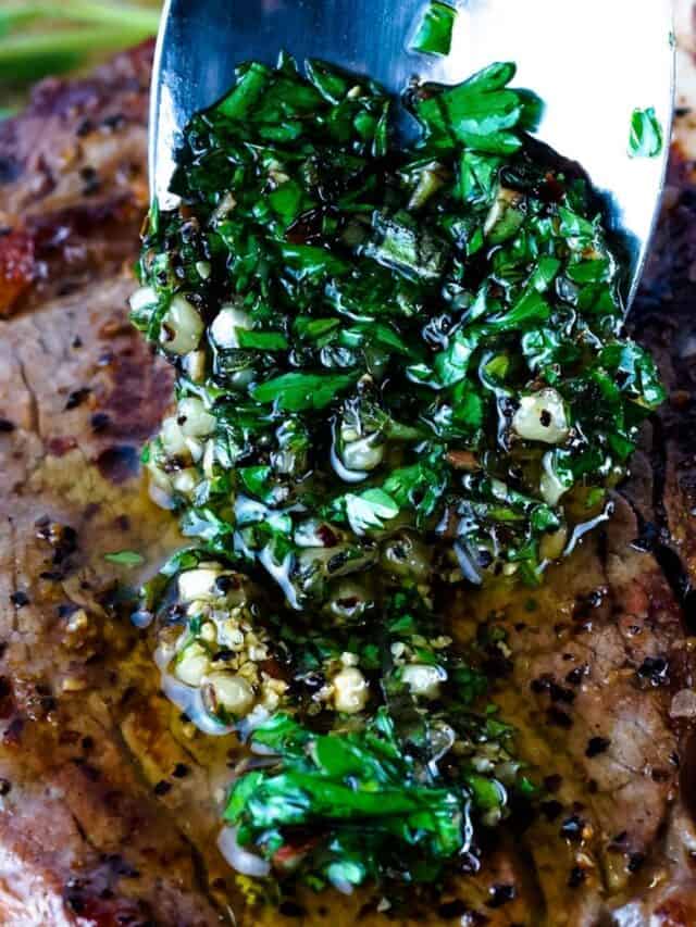 Chimichurri sauce being topped over steak.