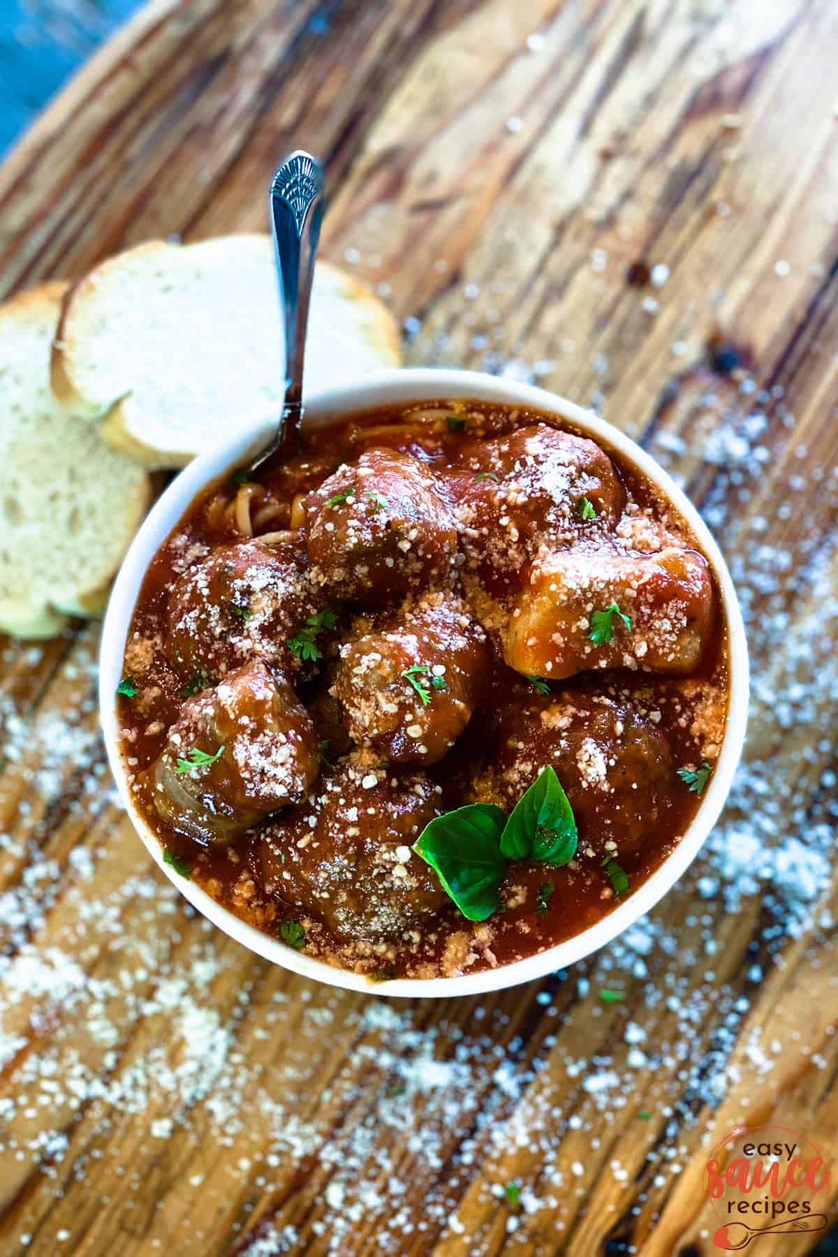 Meatball sauce with meatballs in a bowl next to bread