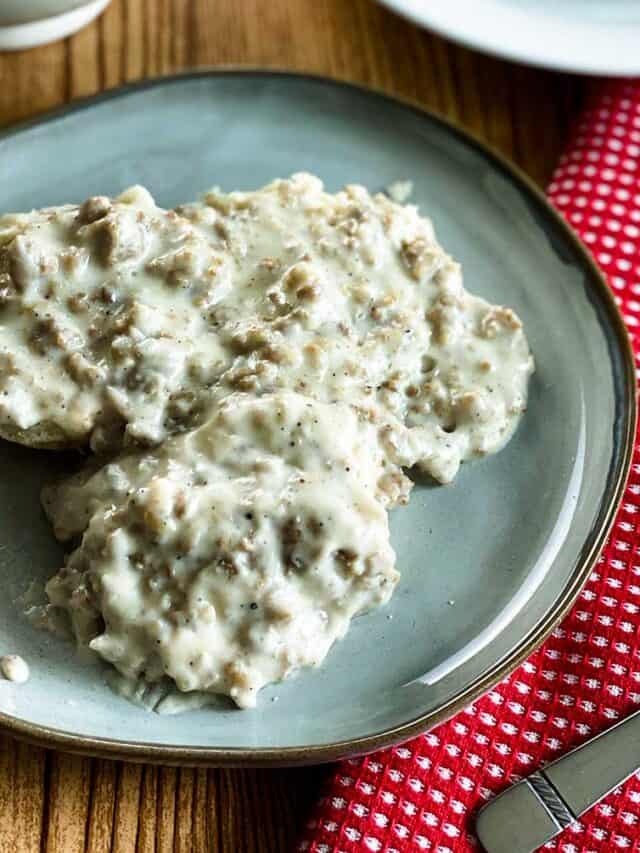 Biscuits and gravy on a plate with a red spoon