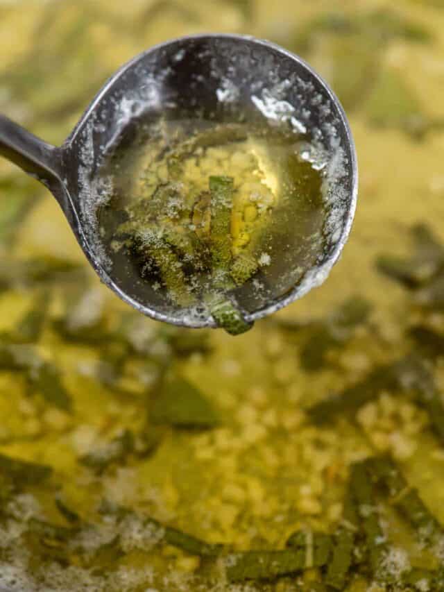 Sage butter sauce in a ladle over a skillet of sauce