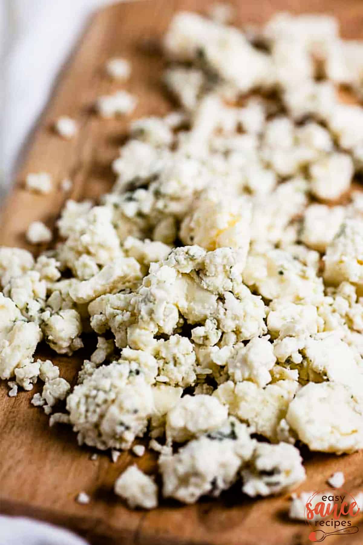 blue cheese crumbles on a cutting board