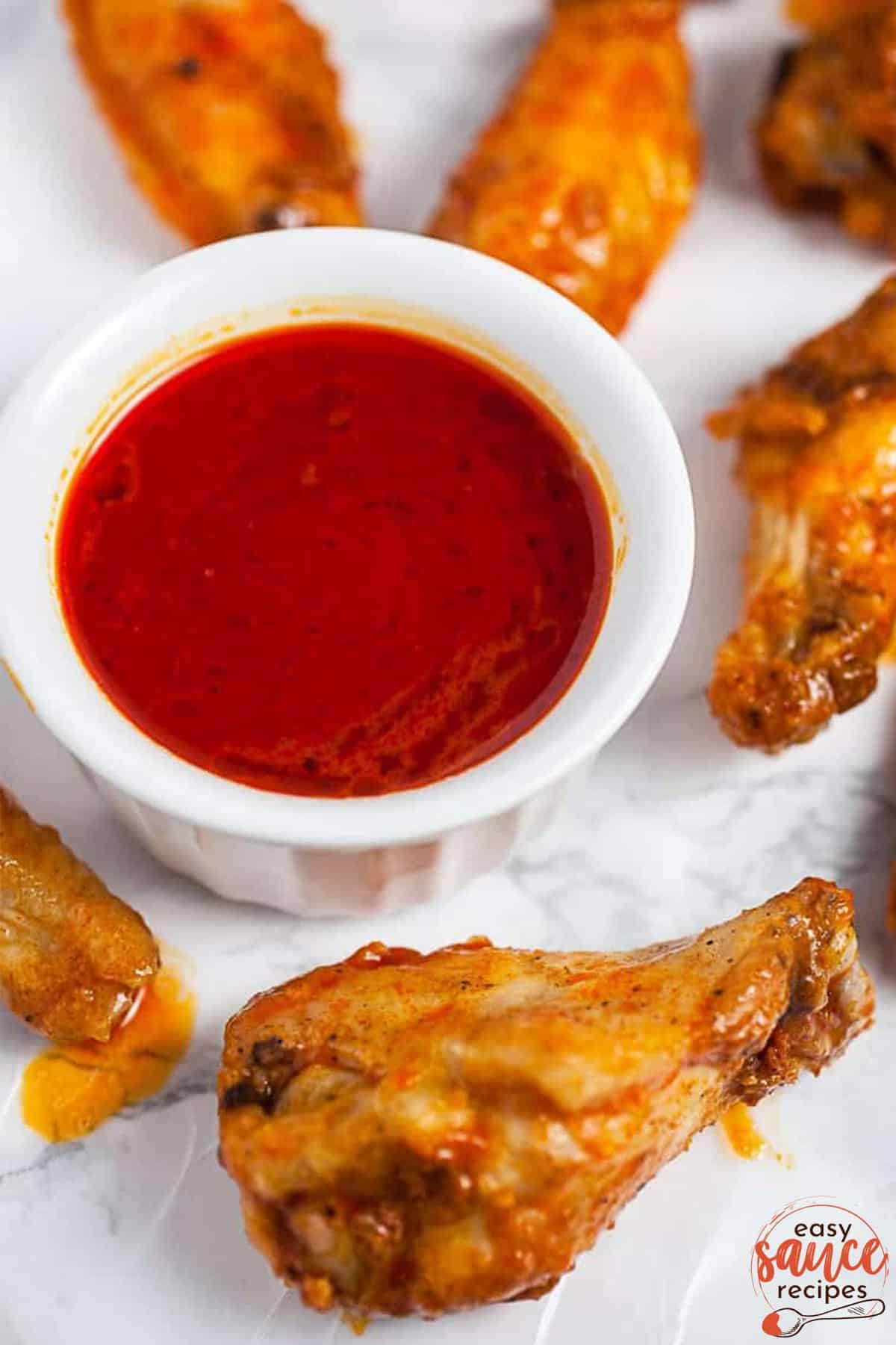 buffalo sauce in a bowl with chicken wings