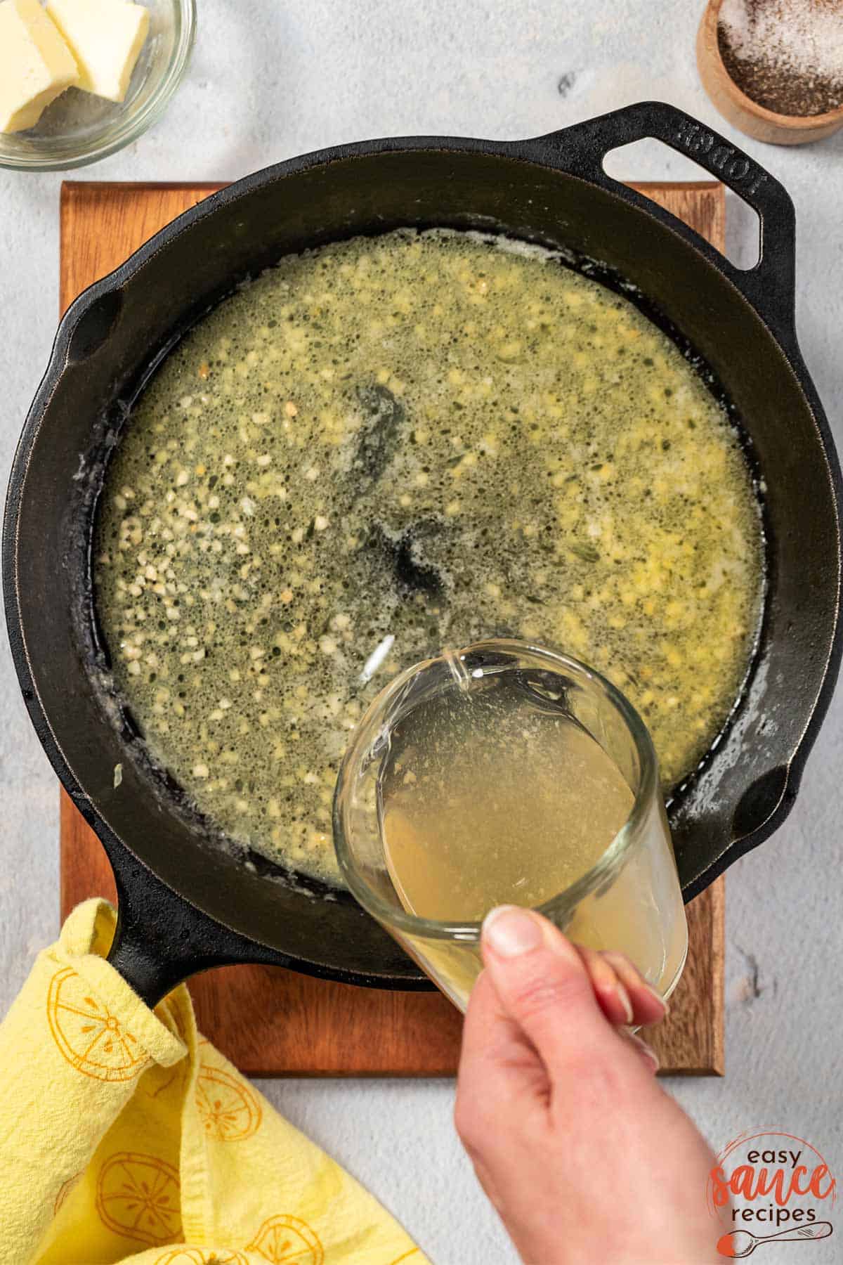 adding white wine to lemon butter sauce in pan