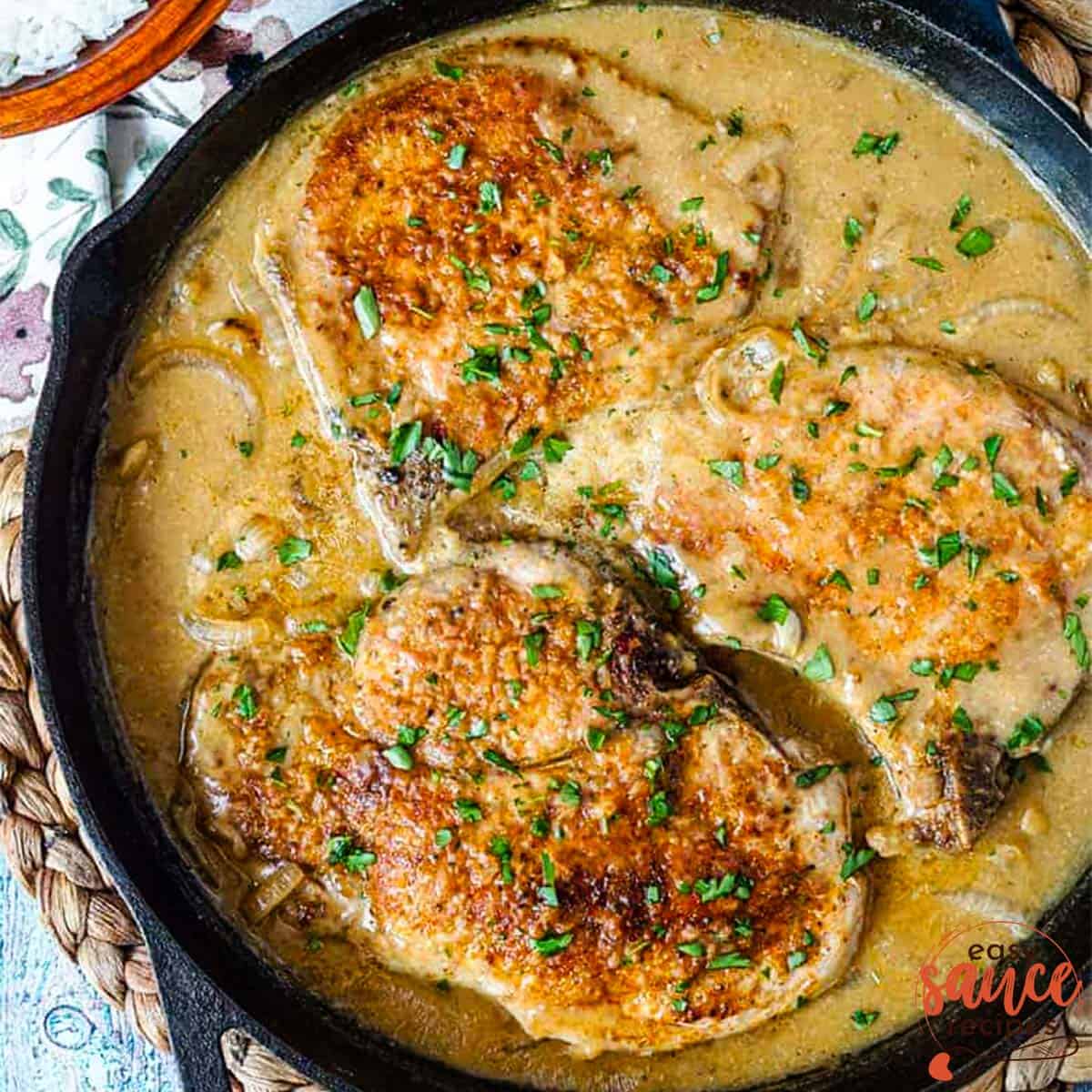 onion gravy in a skillet with pork chops