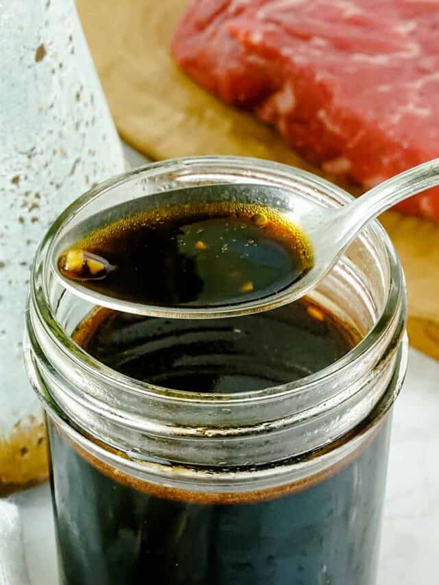 Asian marinade on a spoon over a jar of marinade
