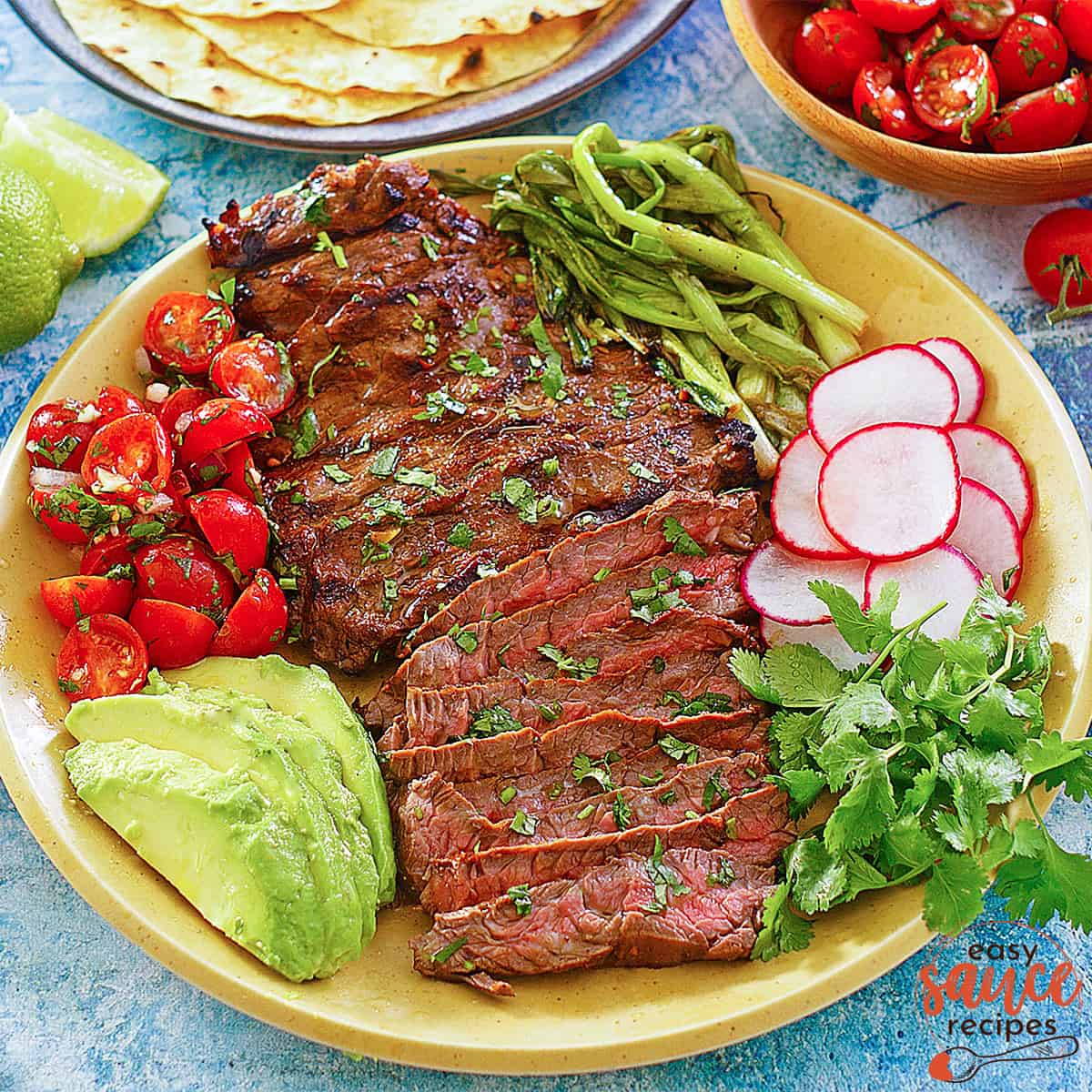 sliced carne asada meat on a plate with vegetables