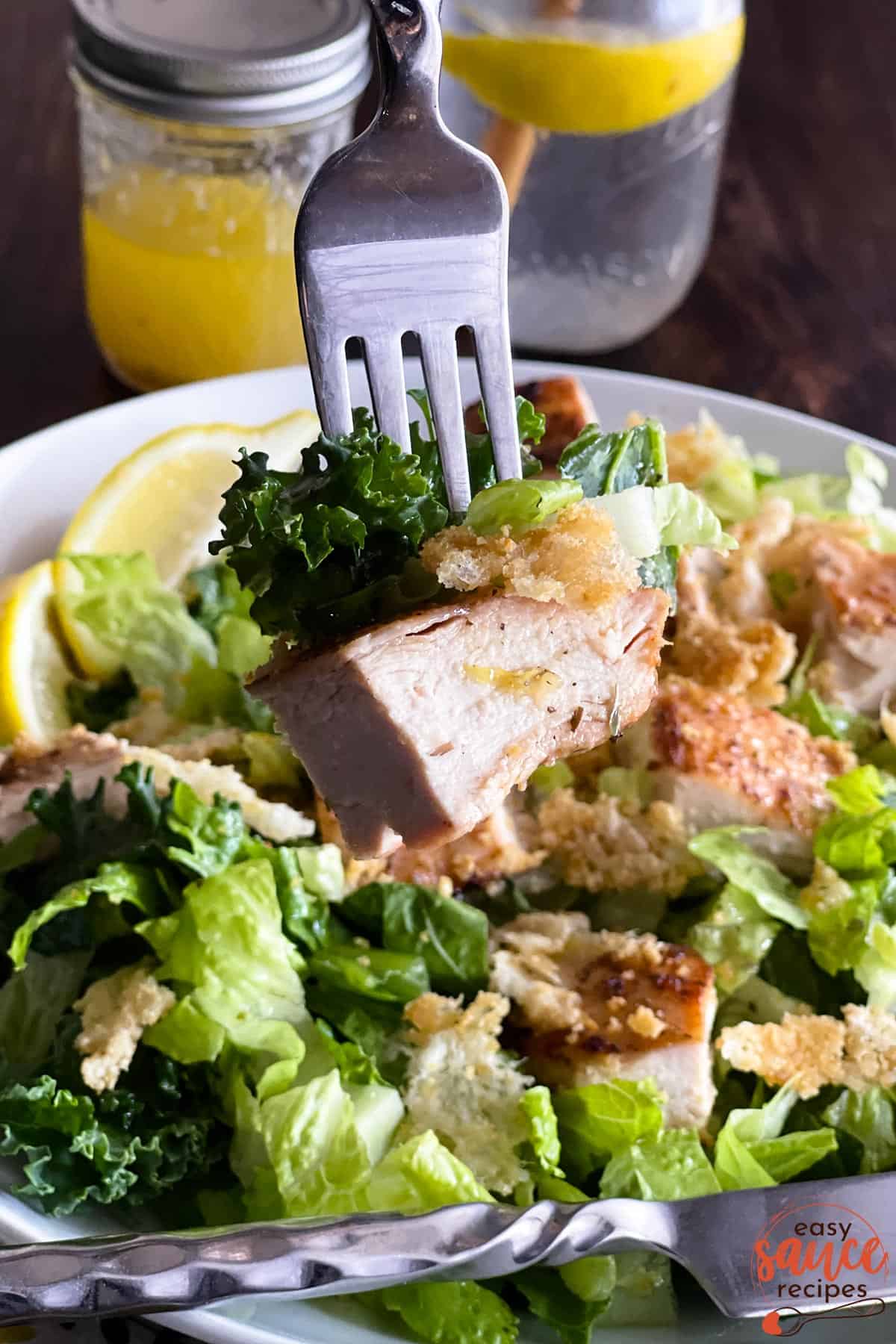 caesar salad on a fork with lemon vinaigrette in a jar