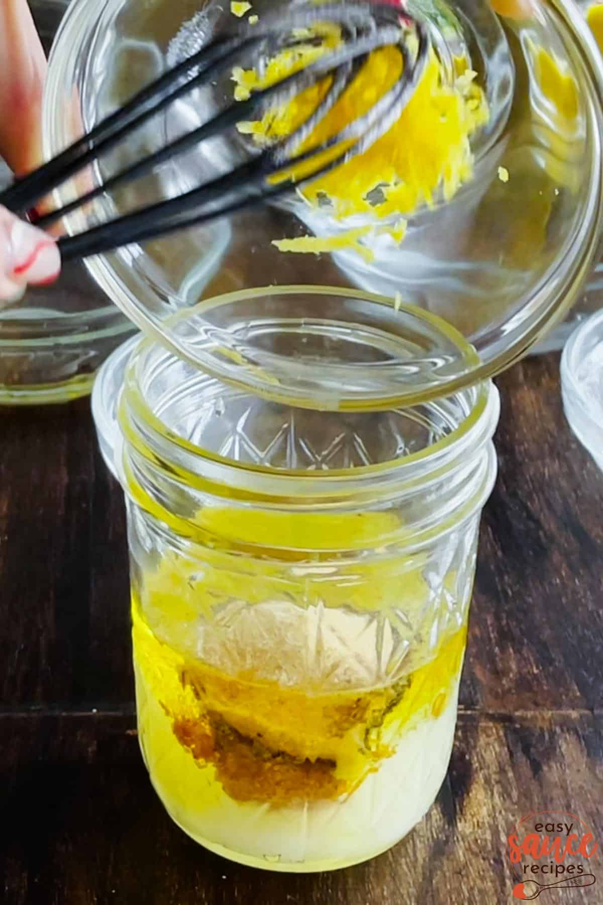 adding lemon zest to vinaigrette in a jar