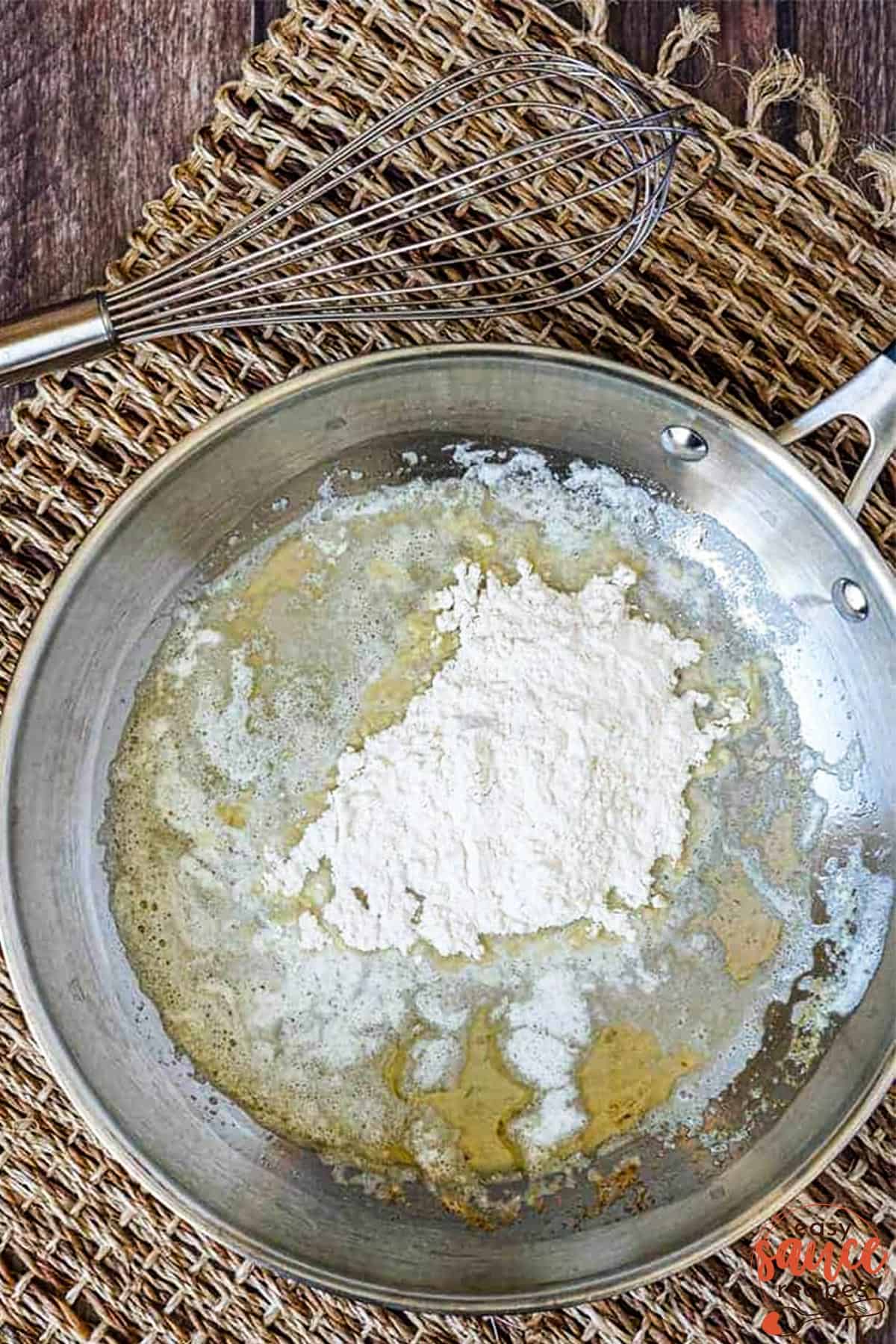 Adding flour to butter to make a roux