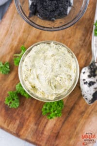 creamy truffle butter in a jar with herbs next to it