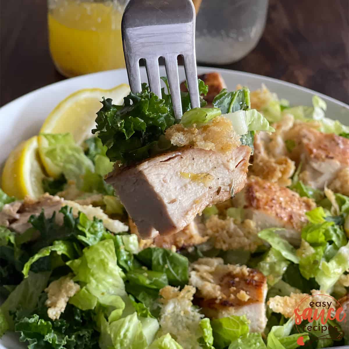 Grilled chicken on a fork over salad