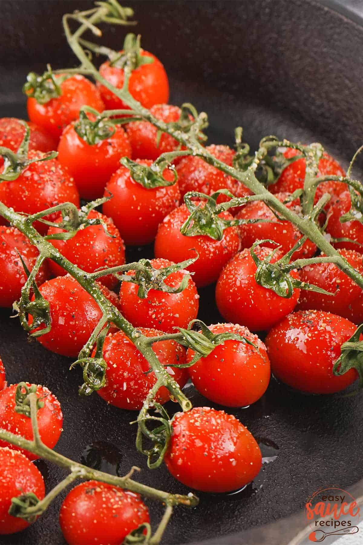 seasoned tomatoes on the vine in a skillet