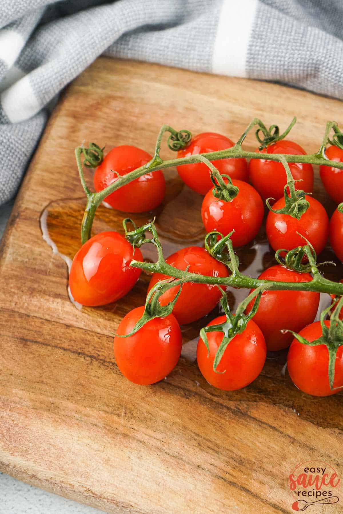 tomatoes drizzled with olive oil on a cutting board