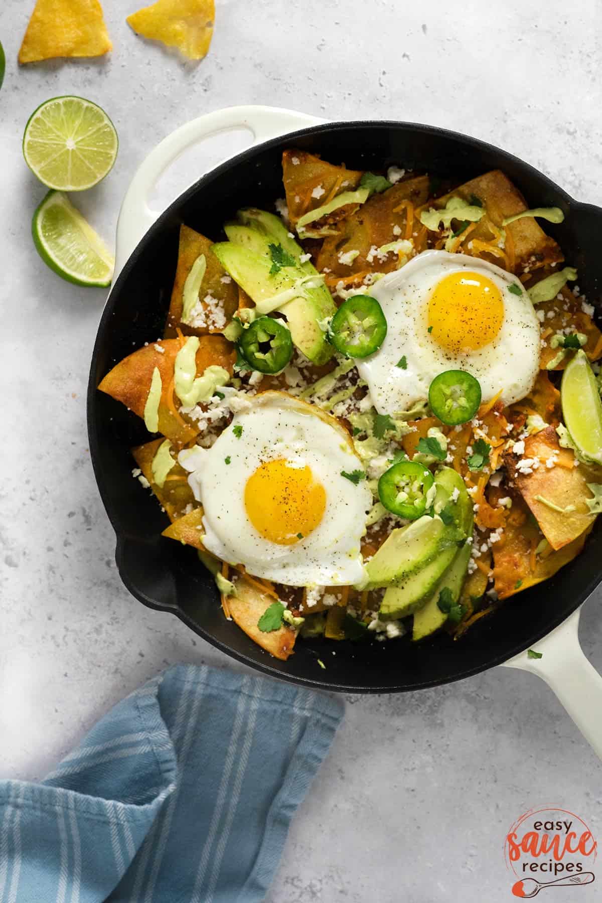 chilaquiles in a pan with avocado crema on top