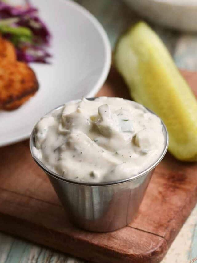 tartar sauce in a little metal bowl with a pickle and fish