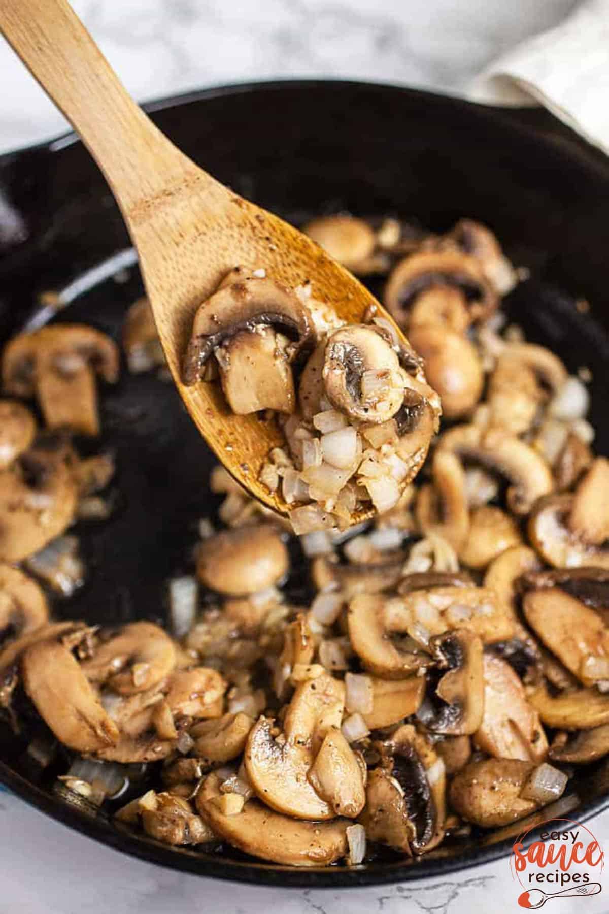 mushrooms on a wooden spoon over a skillet