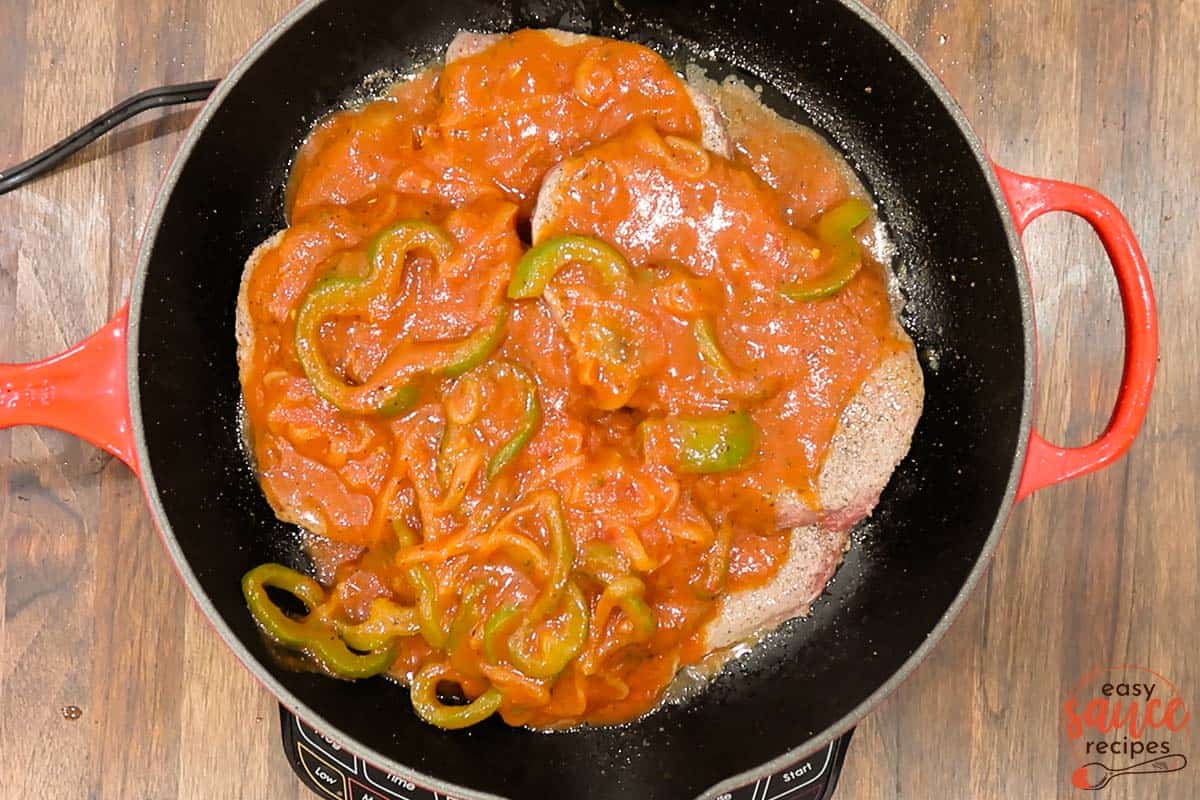 pizzaiola sauce smothering steak in a pan