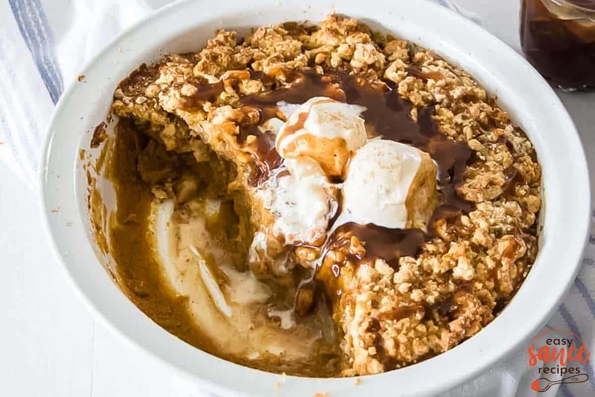 toffee sauce poured over pumpkin cobbler with ice cream on top