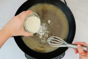 slowly adding flour into a skillet for brown gravy