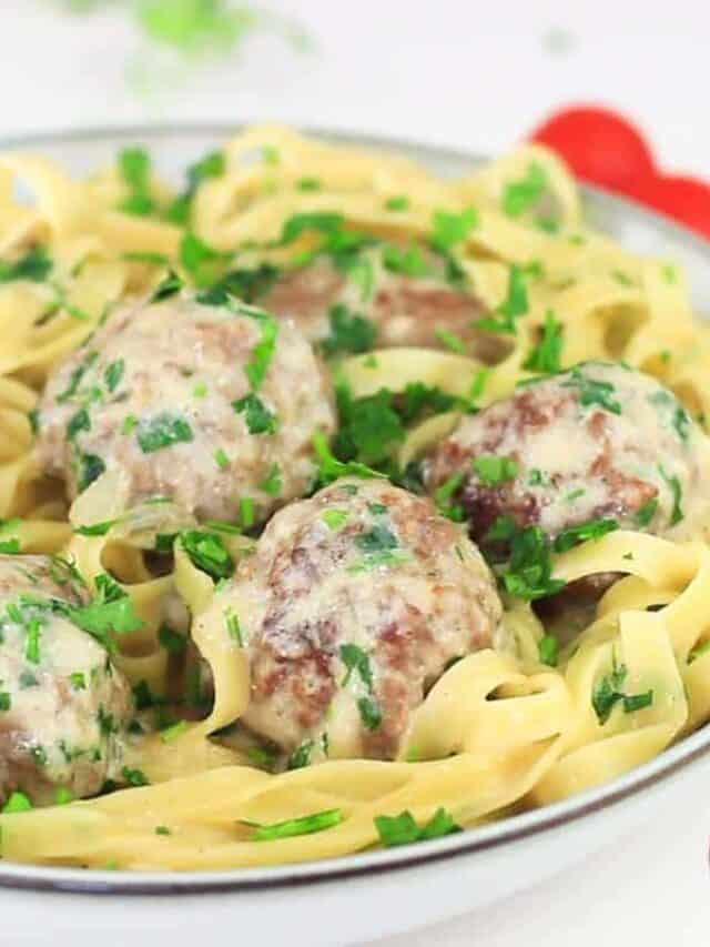 swedish meatballs with sauce and pasta in a white dish