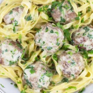 swedish meatballs over noodles with parsley and parmesan