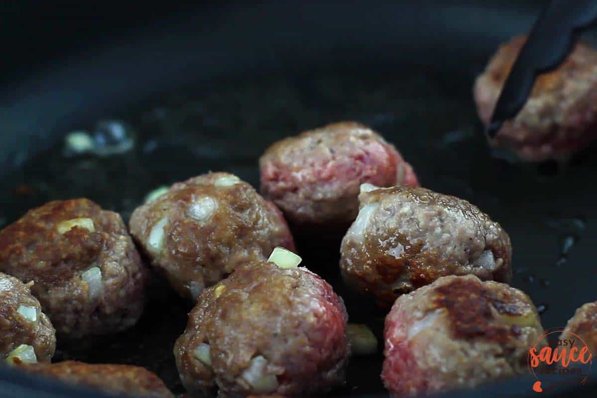 swedish meatballs cooking in a pan up close