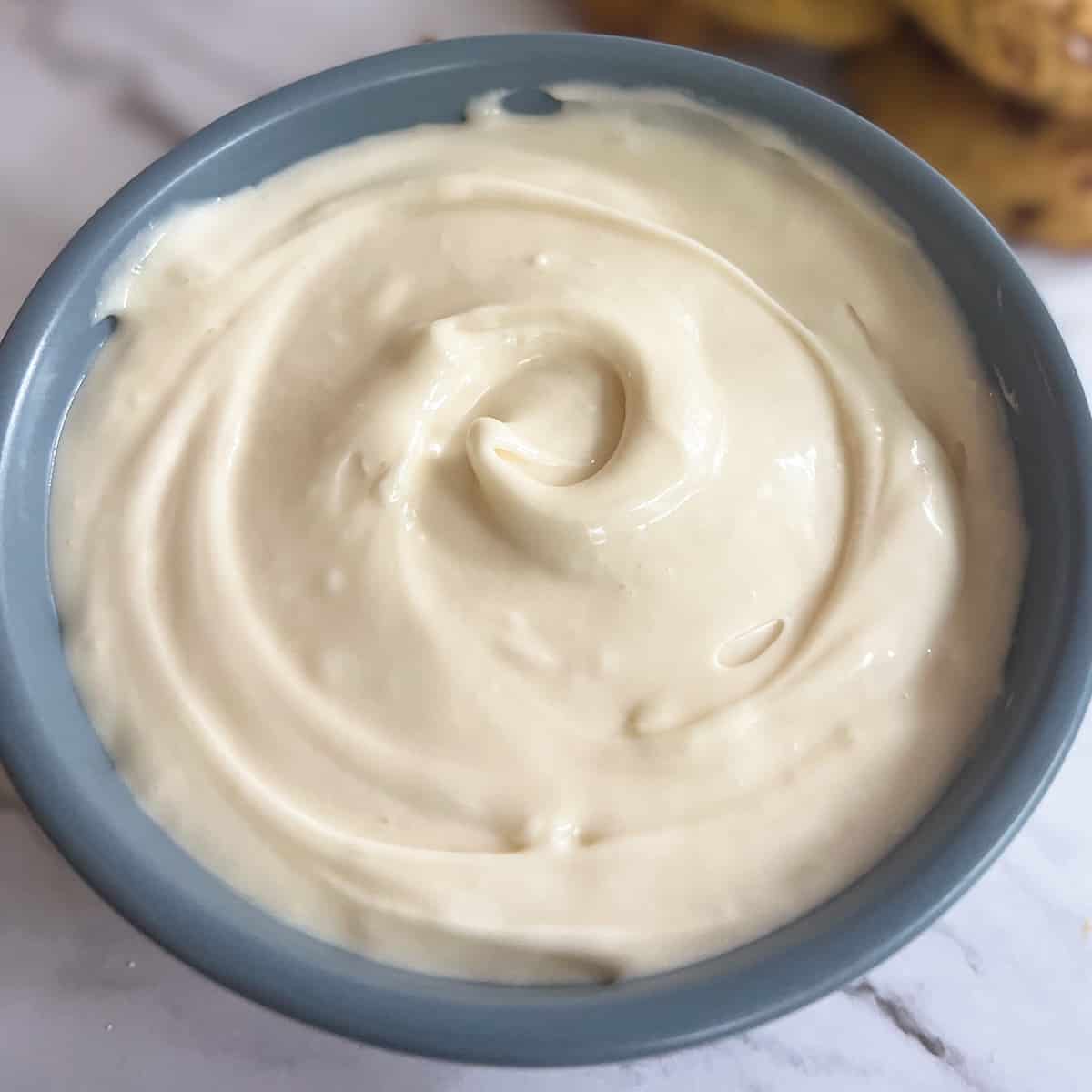 cream cheese frosting in a blue bowl